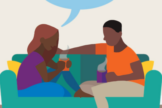 This image shows a couple sitting on a couch with coffee talking.